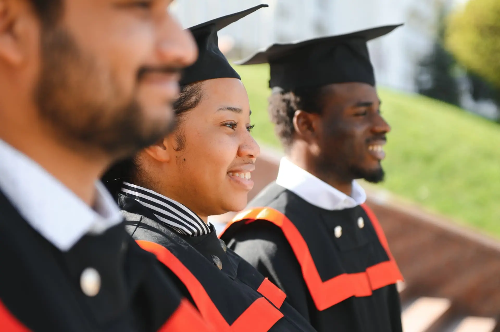Smiling graduates in caps and gowns at a graduation ceremony